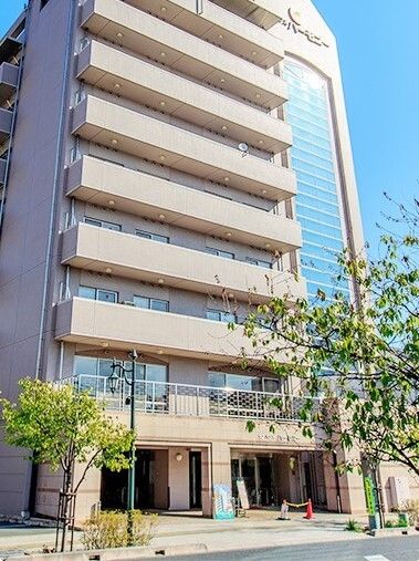 9階建てのビル。マンションのような見た目で、前には木が植えられている