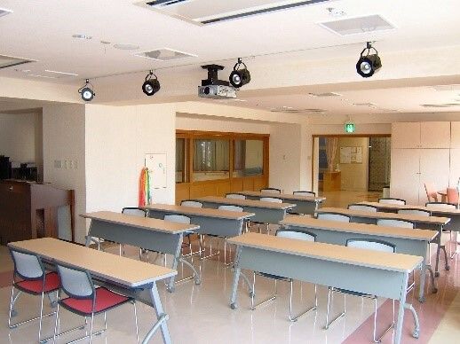 会議室のような共有スペース。三人座れる横長のテーブルがいくつも並ぶ