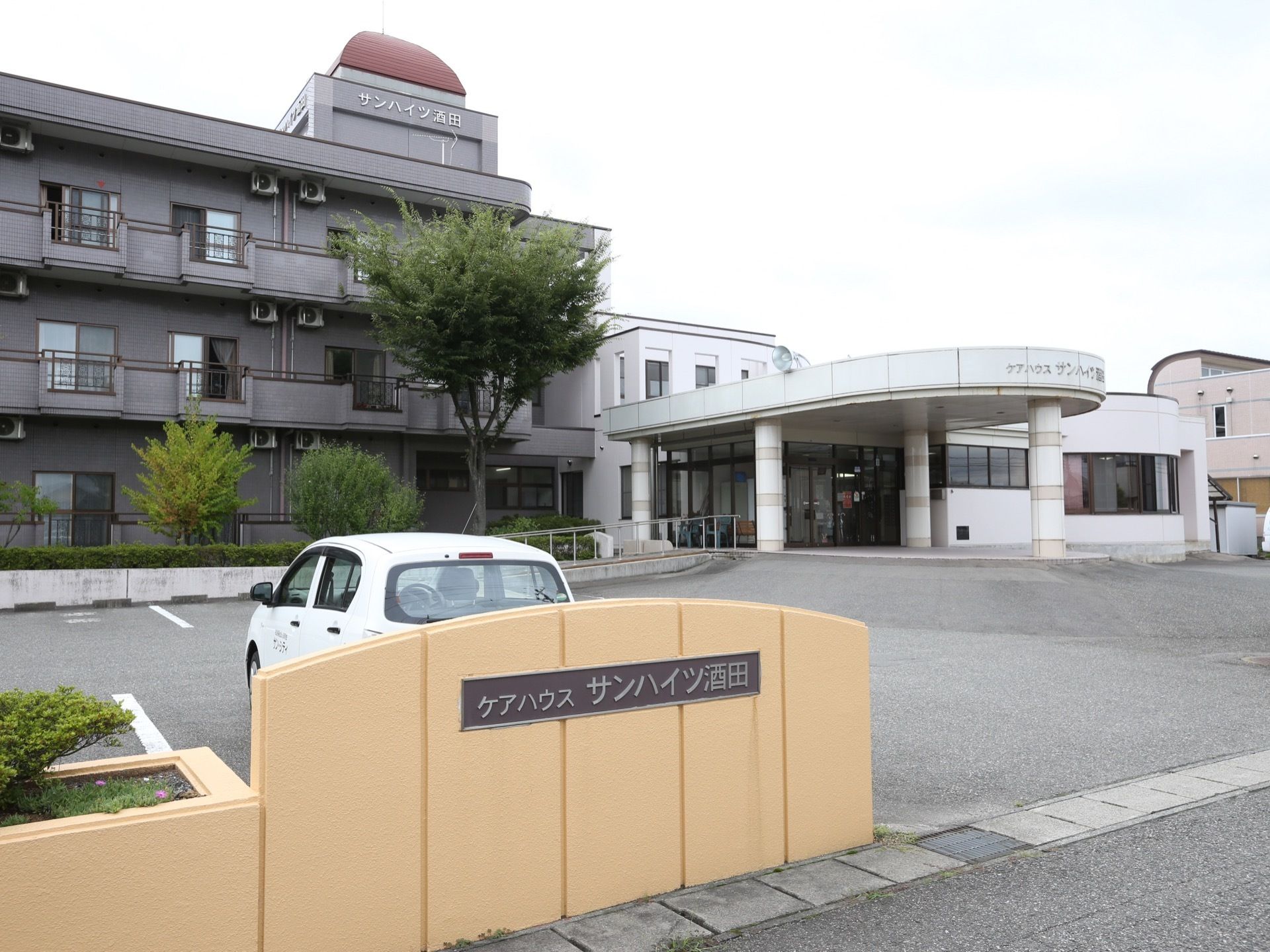 駐車場の出入口の近くには施設の表示板がある。ステンレス製の立体文字で道路側から速やかに確認することができる。