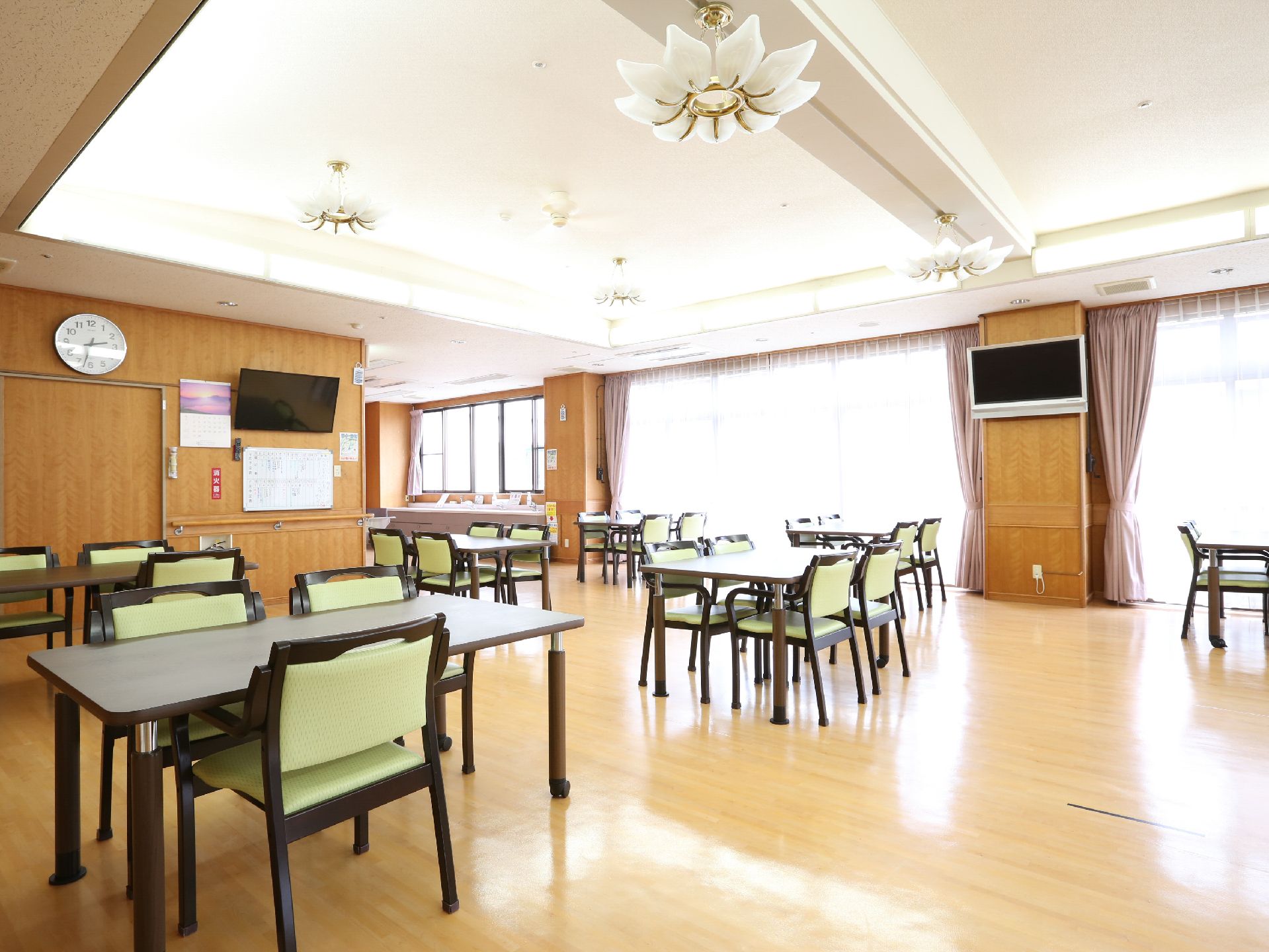 天井が掘り込まれ、デザイン性の高い照明器具が設置されている明るい食堂