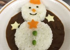 にんじんやグリーンピースなどをトッピングしてスノーマンをデザインしたカレーライス