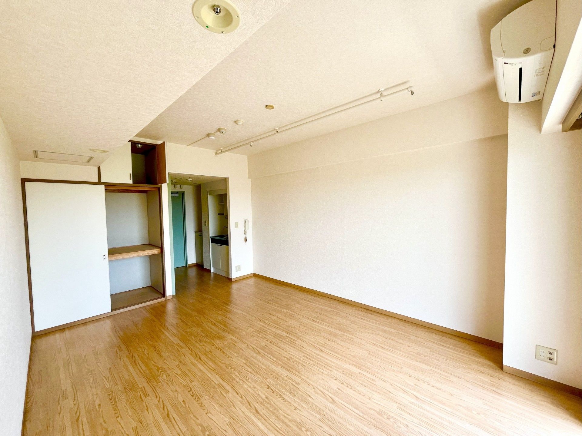 居室に、２人掛けのソファ１台と１人掛けのソファ２台が、ローテーブルを囲むようにして置かれている。台の上にテレビが載っている。