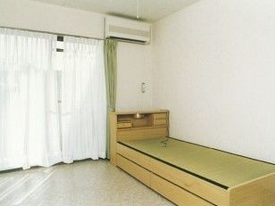 収納付きの畳ベッドやエアコンが設置された居室の窓にはカーテンも設置されている。