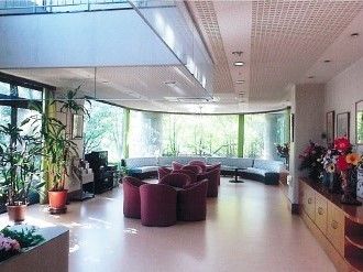 応接セットや楕円形に置かれたソファ、テレビなどがあるロビーは壁一面が窓となっていて明るい。