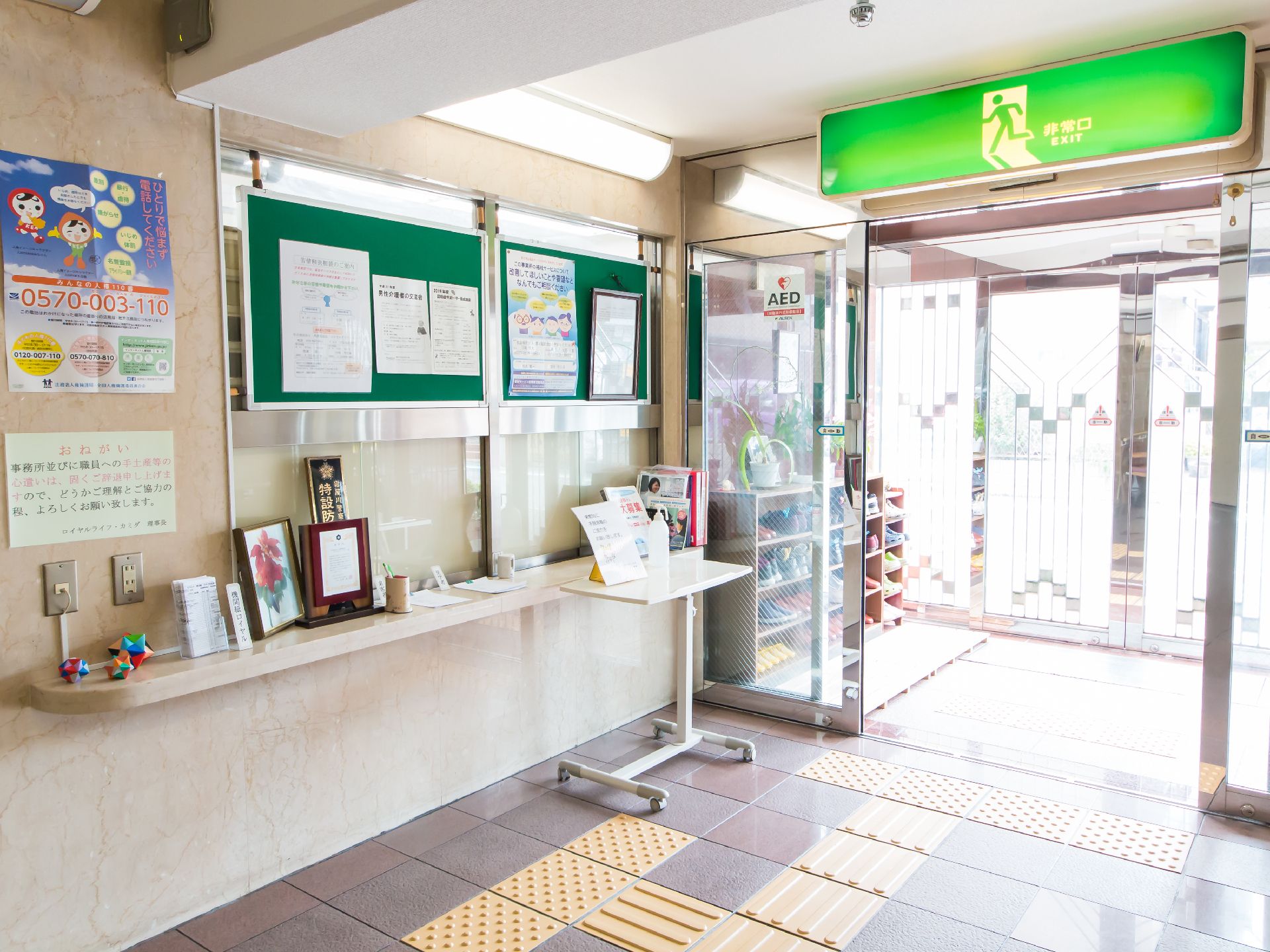 非常口の大きな緑色のサインが表示されている玄関内部