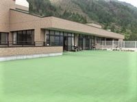手前に緑の床が広がる施設外観。高齢者向けケアハウスの外観写真