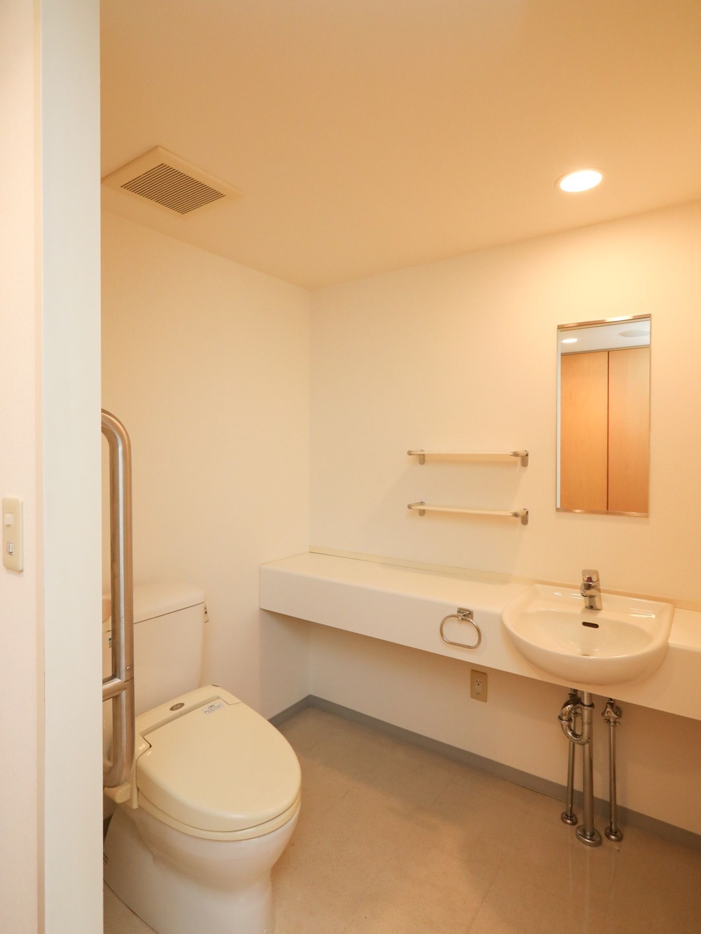 白で統一されたトイレで、清掃が行き届いている。広々としており、随所に手すりが備わっているので、車椅子や歩行器でも安心して利用できる。