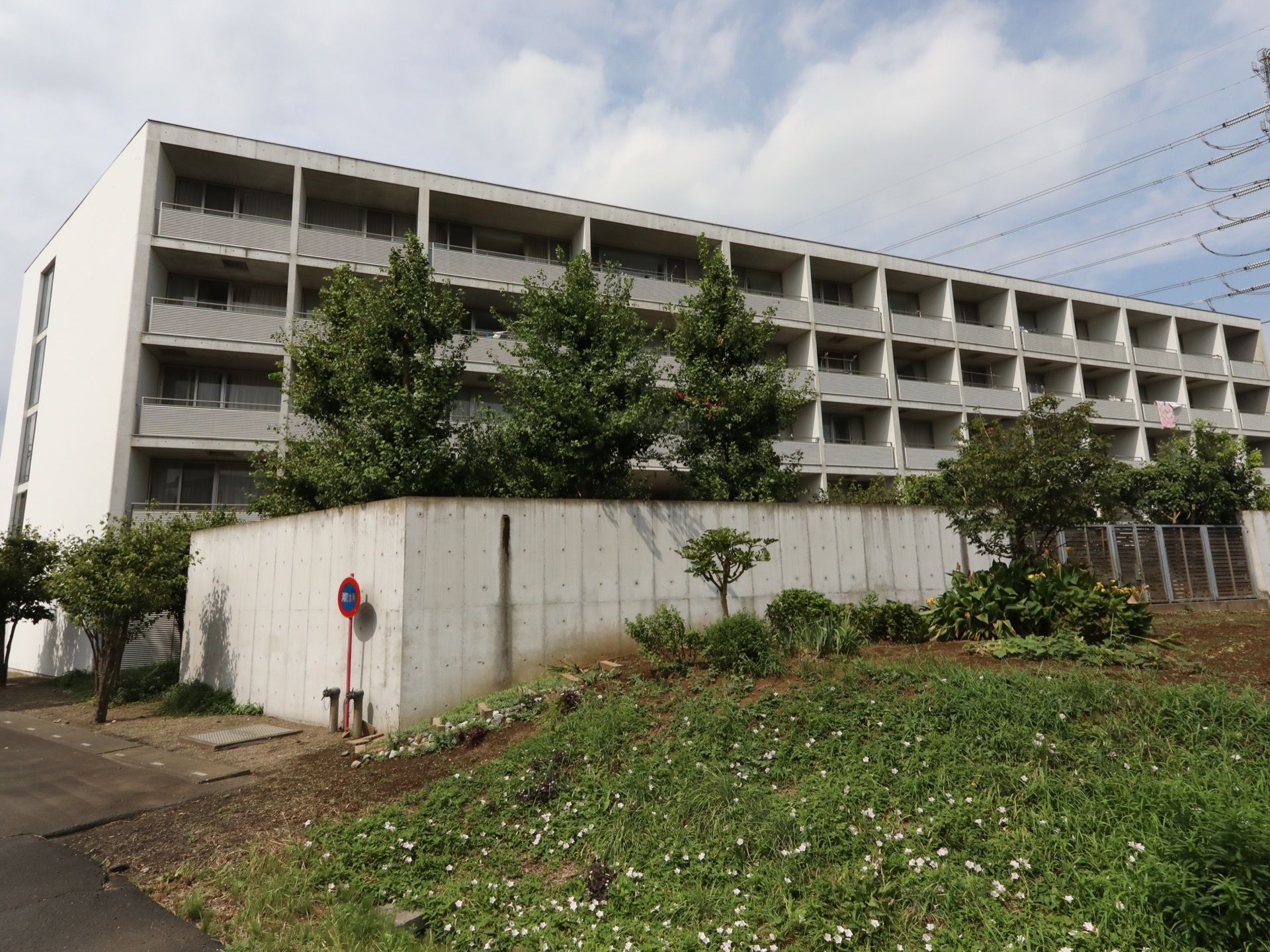 集合住宅のような外観の５階建ての建物である。居室には、バルコニーが設けられている。敷地の周囲にコンクリート塀がある。