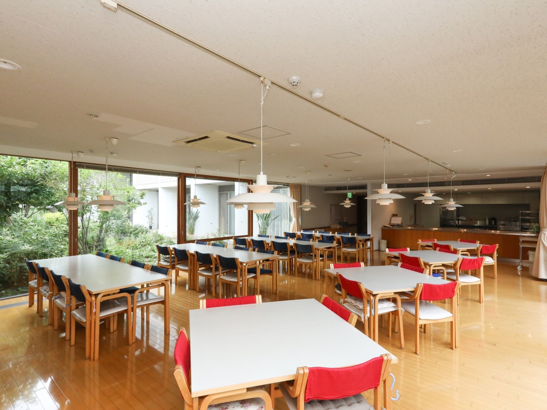 光あふれる開放的な食堂である。厨房が併設されている。スタイリッシュでモダンなデザインのインテリアでコーディネートされている。