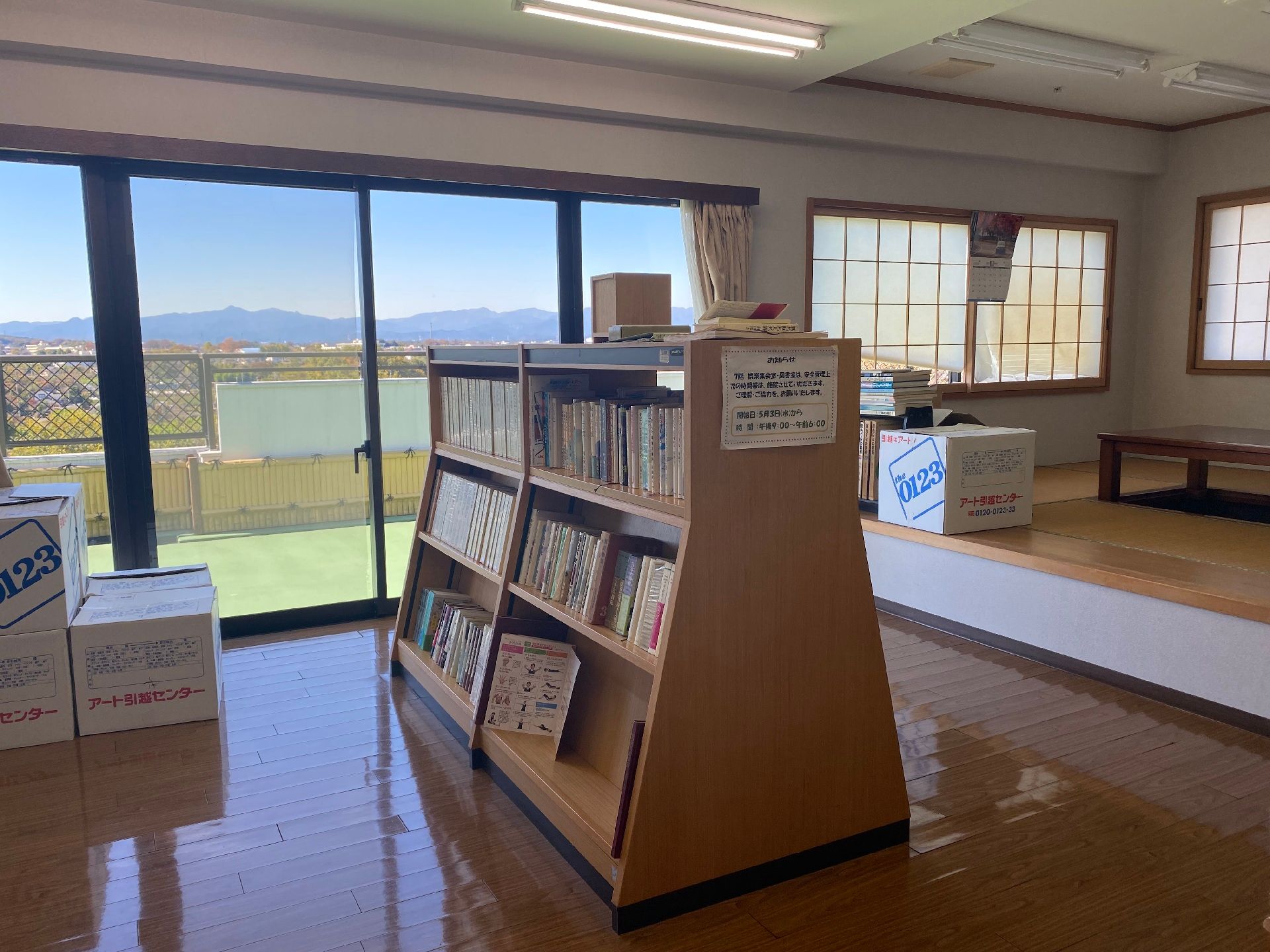 本がたくさん並べられた本棚があるフローリングのスペースの一角には、机が置かれた畳スペースもある。