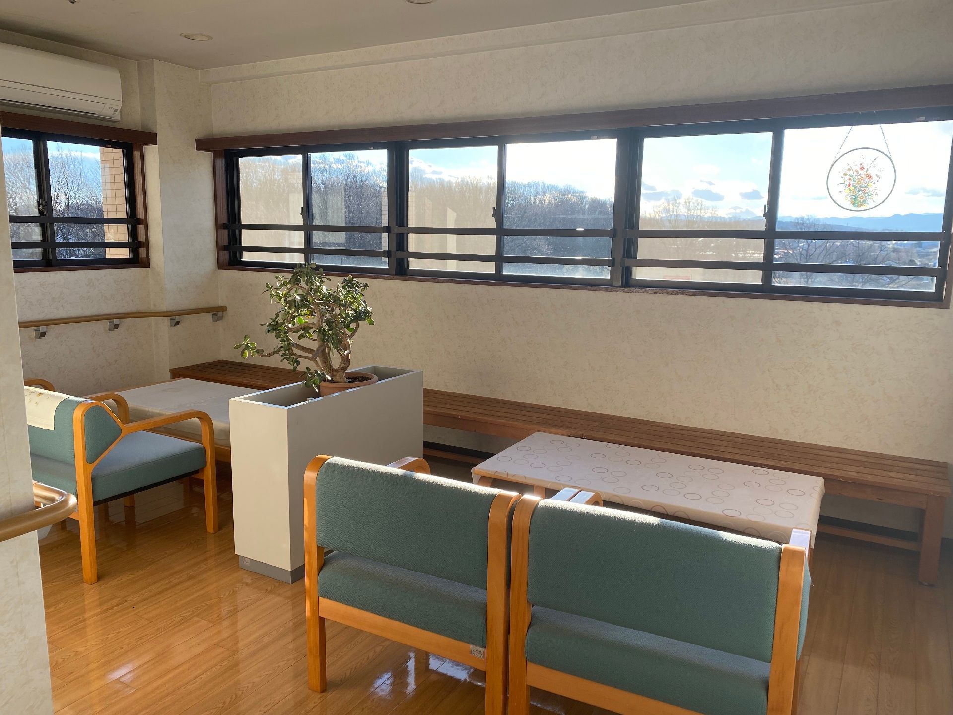 テーブルが二組設置され、窓際には長いベンチがあり、反対側には椅子がセットされている。