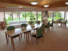 大きな窓が付いた食堂からは庭を眺めることができ、食堂にはダイニングテーブルが置かれている。