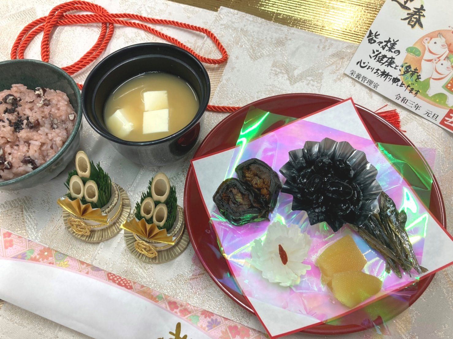昆布巻きと黒豆と数の子や田作り、赤飯と味噌汁の付いたメニュー