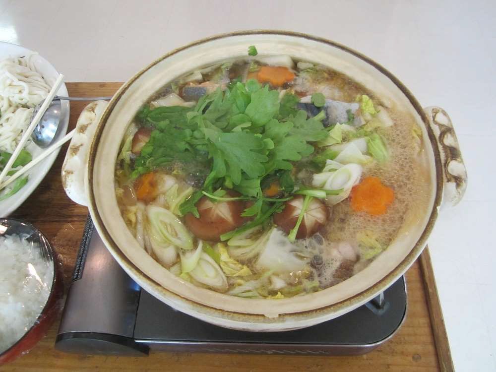 魚やきのこや野菜の入った鍋が煮える様子
