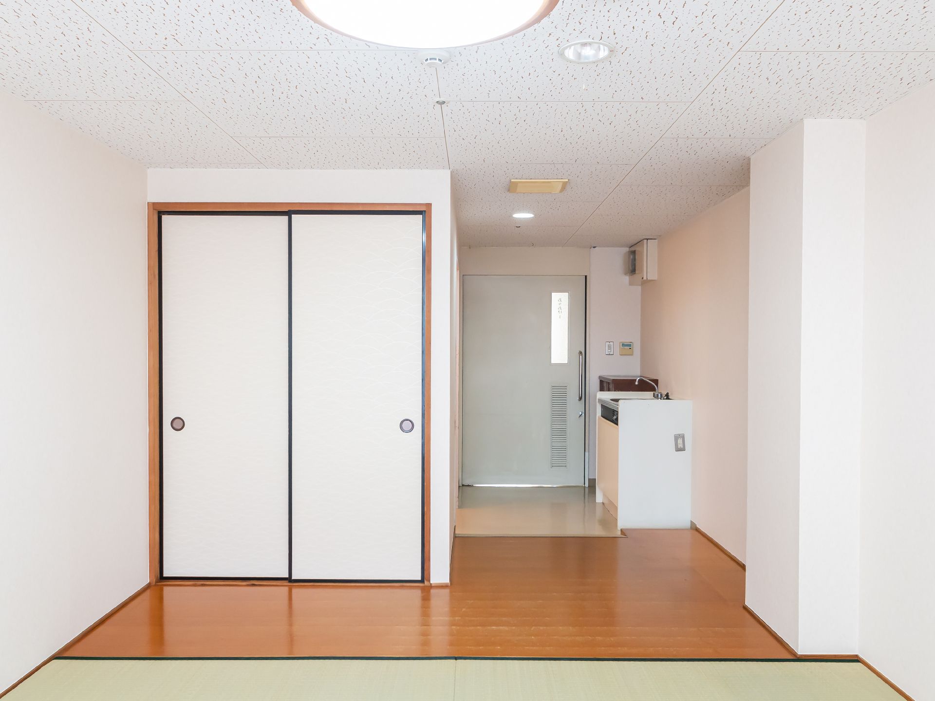 ふすまと洗面台が見える白い壁の部屋