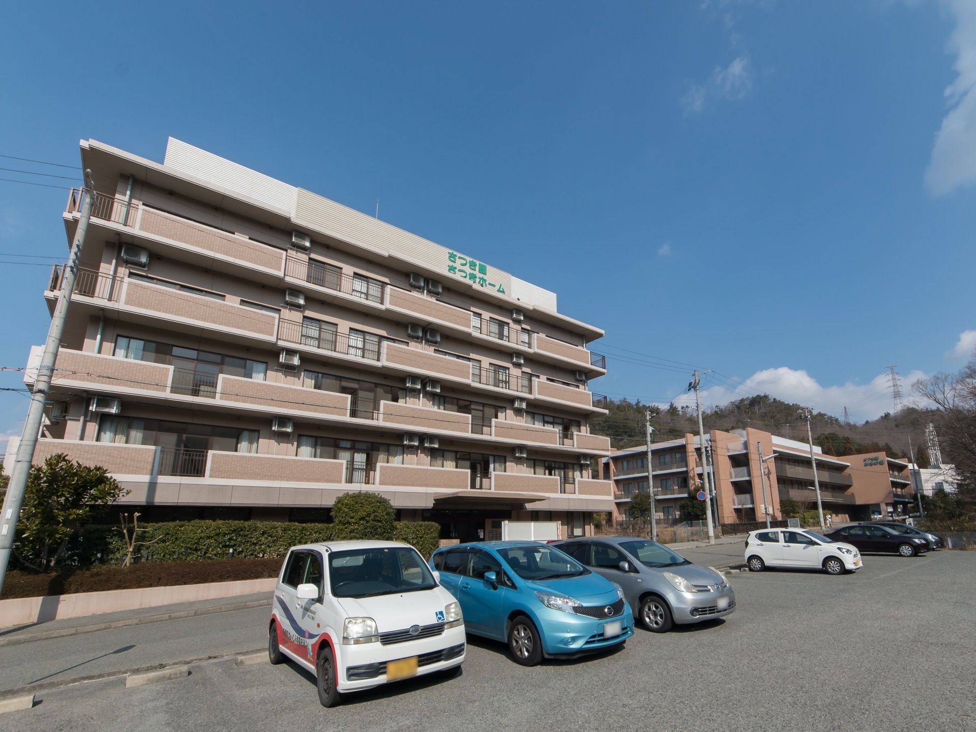 道路を挟んで施設の向かいに駐車場がある。広々としていて、余裕をもって車が停められている。施設専用の車両も用意されている。