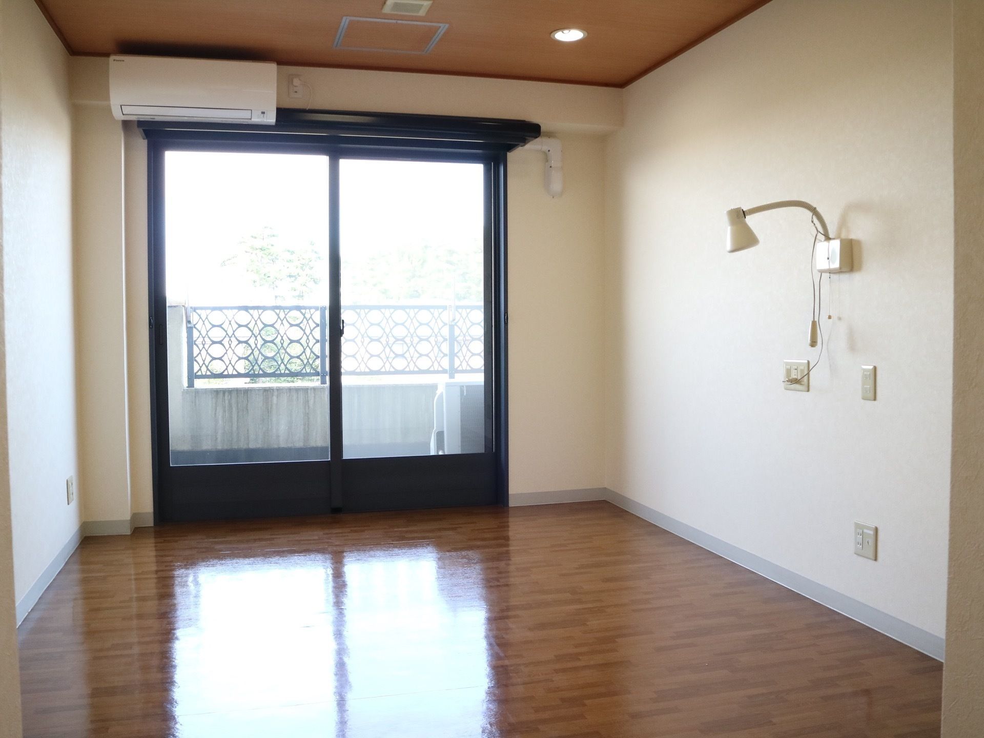 白い壁が室内を明るくみせてくれる居室である。床は濃い茶色で落ち着きが感じられる。また、間接照明がある。