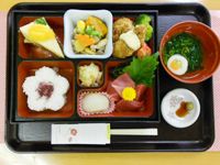 ゆかりごはんと刺身、から揚げや野菜の煮物、デザートのケーキが付いた献立