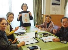 施設内で書道を楽しんでいる高齢者の様子。施設内レクリエーションの一場面