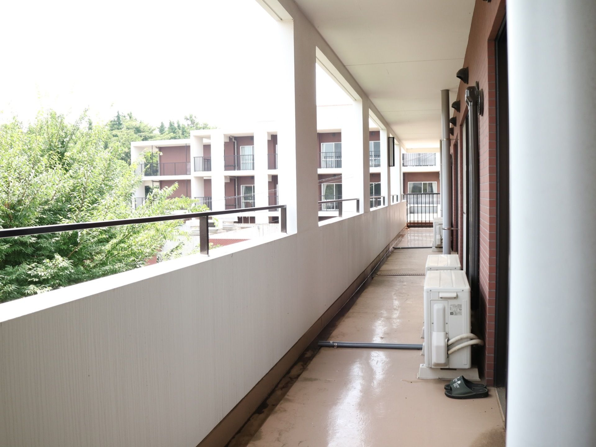 各居室の外には通路のようにつながっているベランダがあり、それぞれの部屋のエアコン室外機がある。