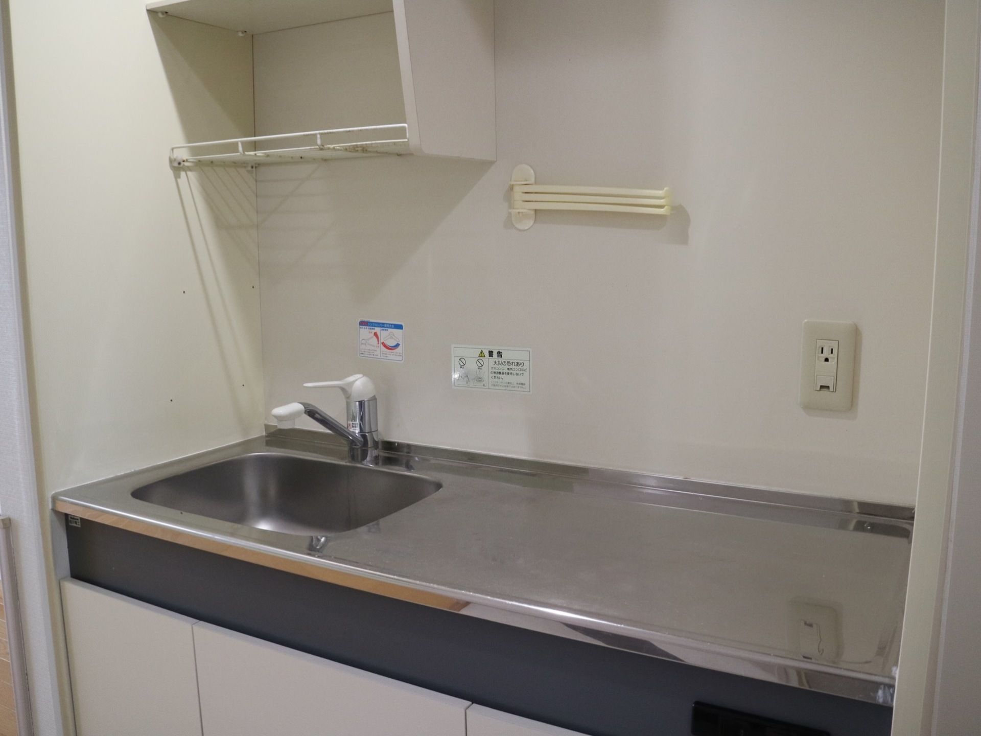 居室に設けられているミニキッチン。流し台の上に食器用の網棚がある。右にはヒーター用のスペースが空いている。