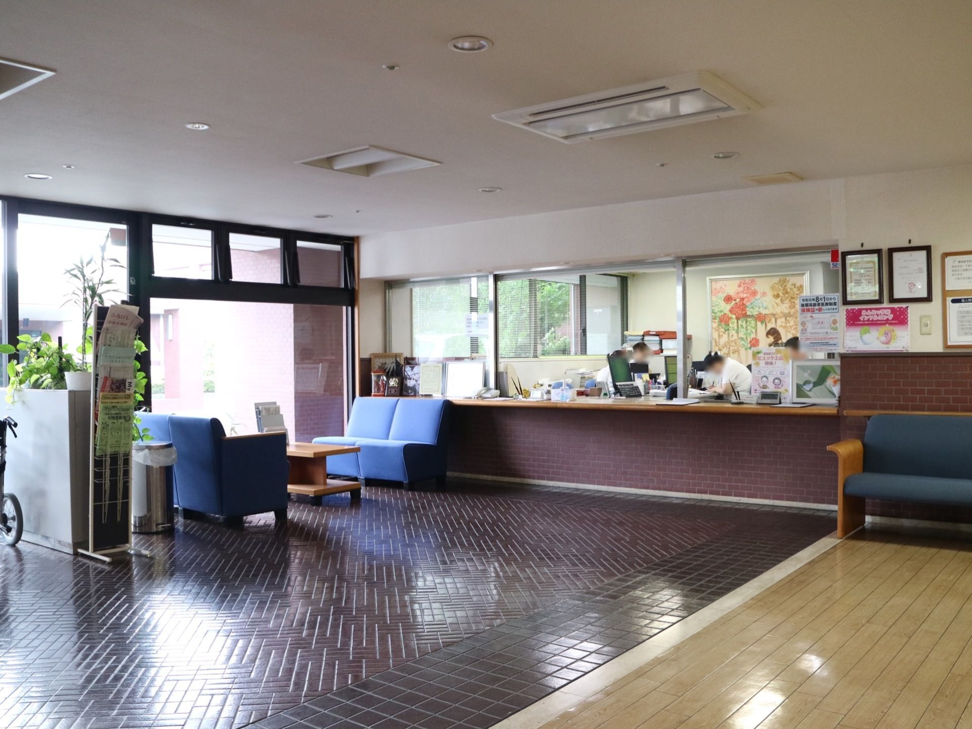 玄関から入ってすぐにあるホール。横長のガラス窓を持つ受付カウンターが設置してあり、その脇にはテーブルとソファを用意。