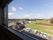 館内の窓から見渡す景色である。まわりは住宅や田畑やが広がっている。敷地には、広々とした駐車場が完備されている。