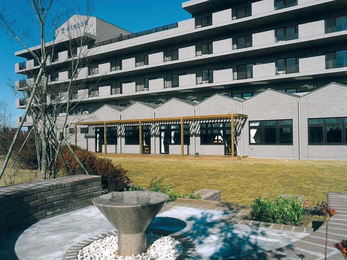 前方に広い芝生がある5階建て建築物
