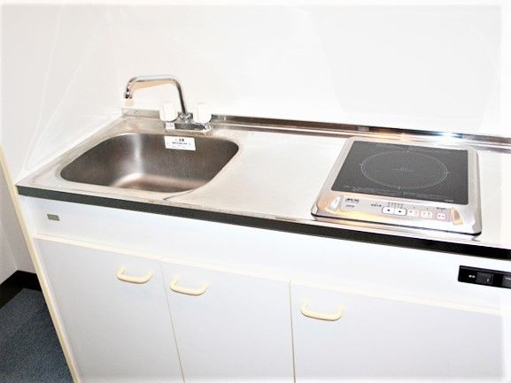 部屋の名k内取り付けてある小さなキッチンスペース。電磁調理器が置いてあるタイプ