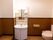 茶色と白のツートーン壁になっているトイレスペースである。洗面台には鏡があり、収納棚がたくさんついている。
