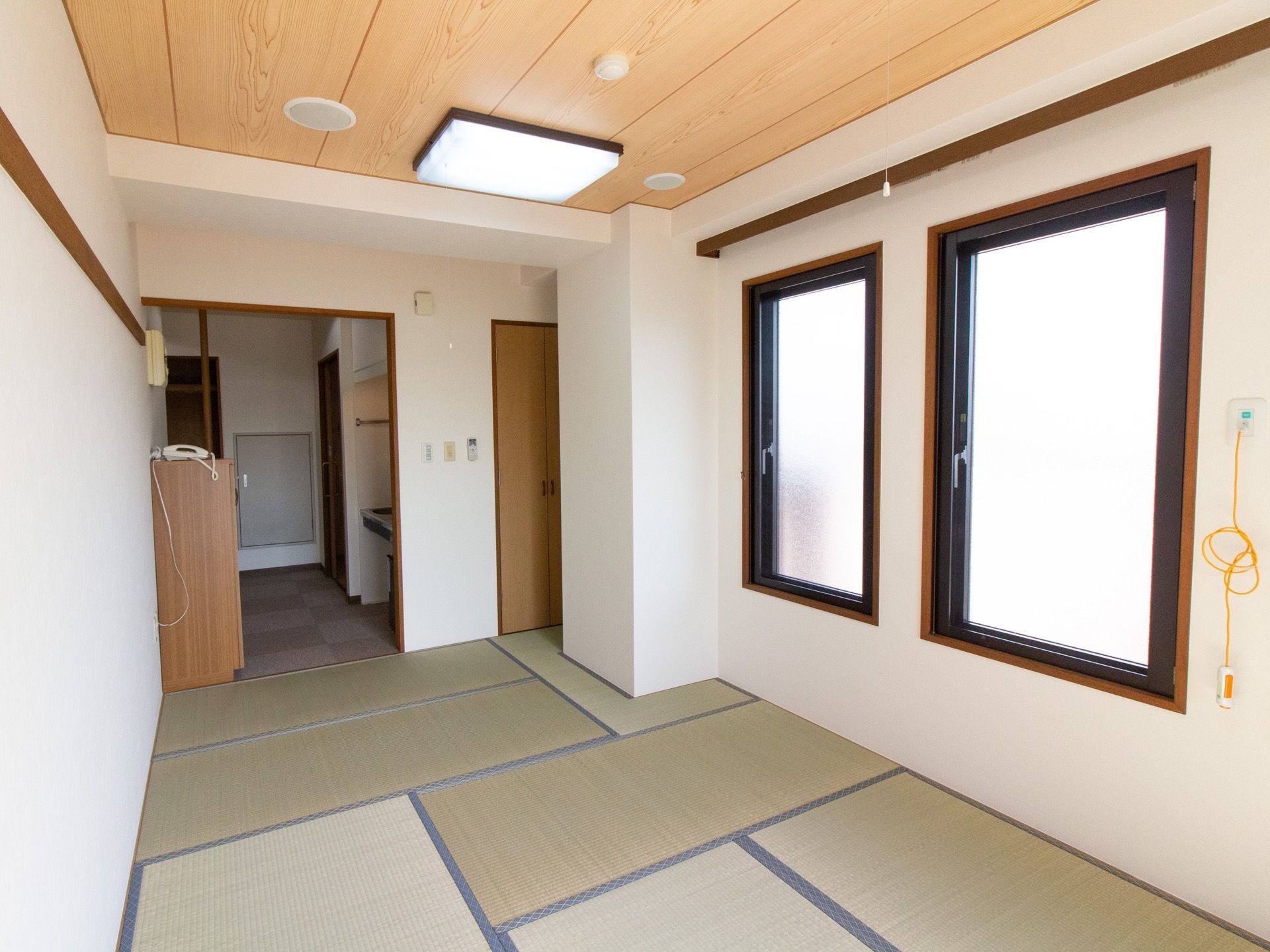 リビングと和室が続く居室である。キッチンや収納などが確認できる。窓が設置され、ケアコールが取りつけられている。