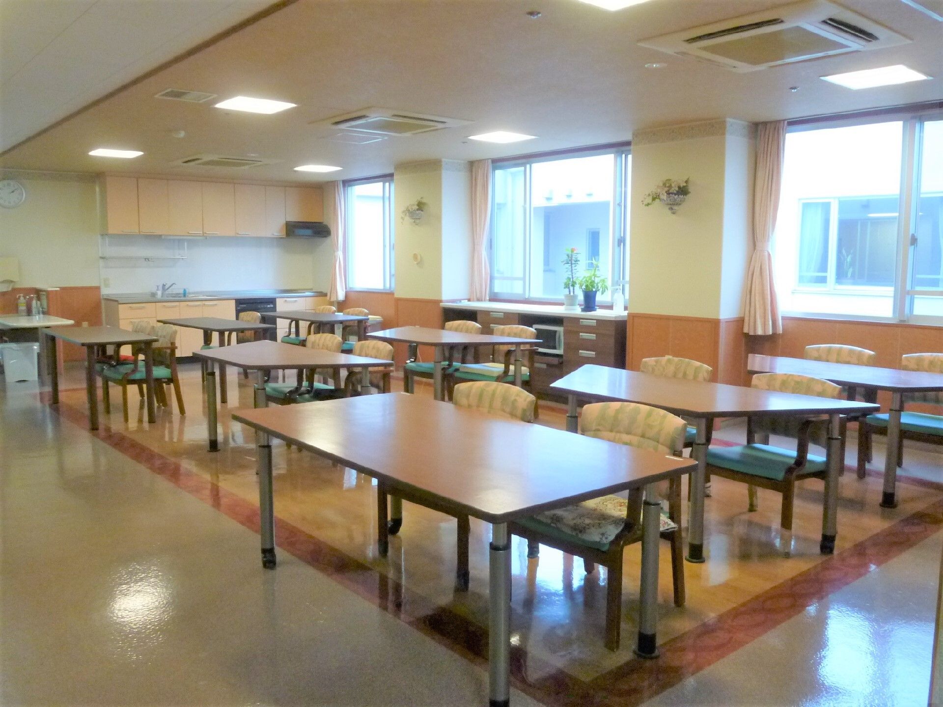 並べたテーブルに、向き合わないように椅子が置かれている食堂