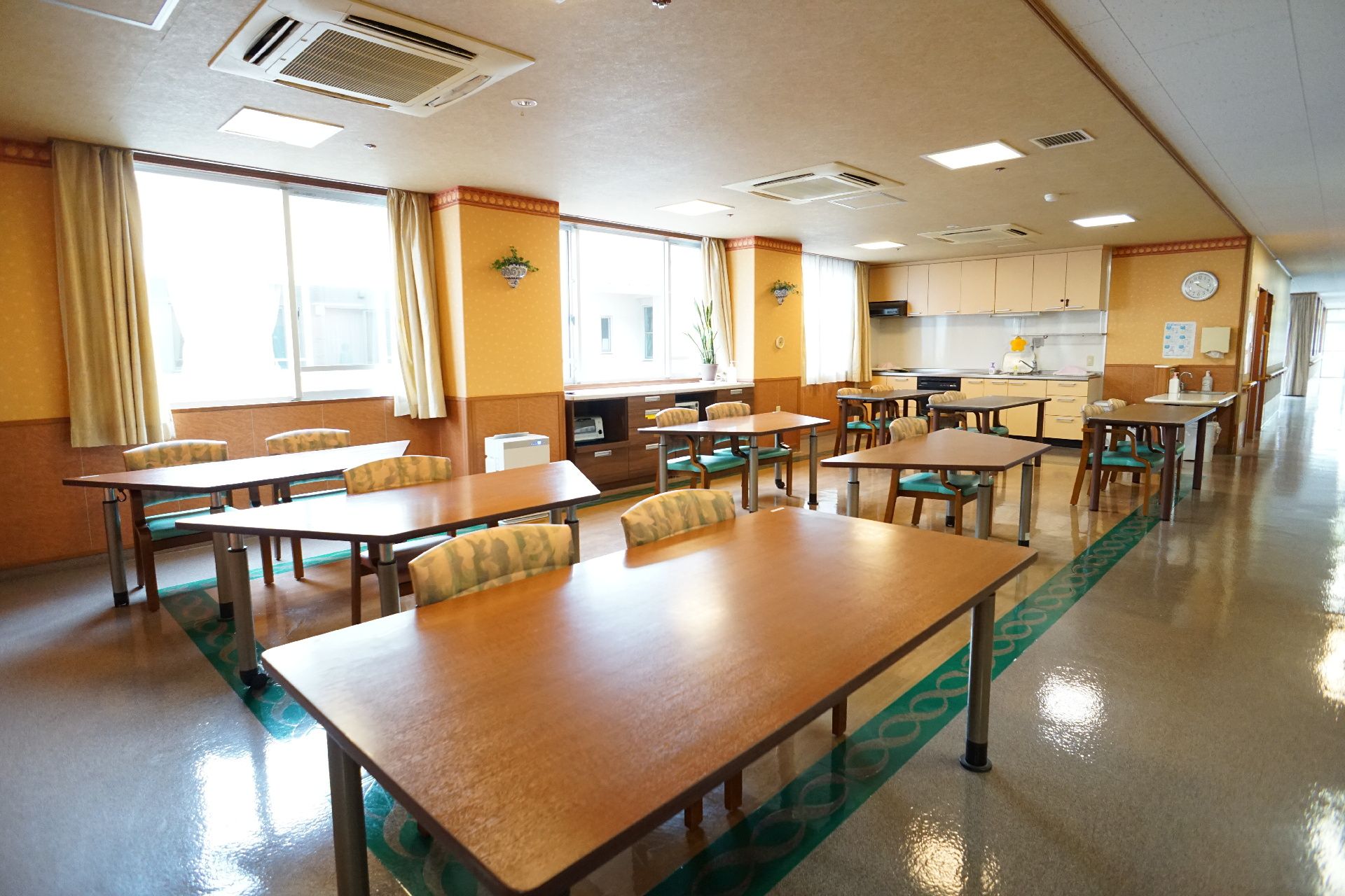 窓が多く取り付けられ、室内を日差しが注いでいる共有スペース
