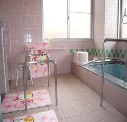 車いすに乗った女性に話しかけるスタッフとの2ショット。笑顔を見せている高齢の女性
