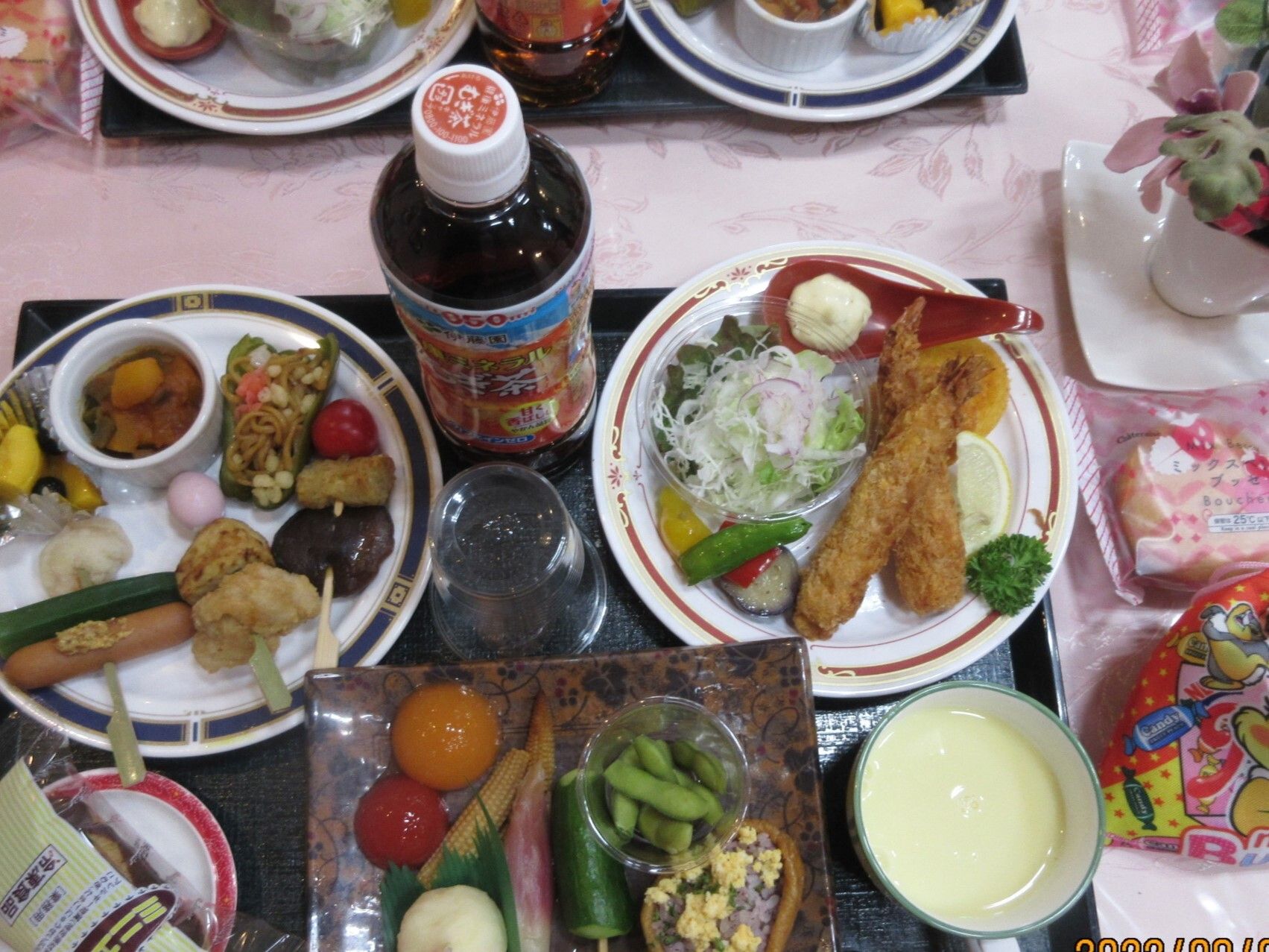 エビフライやおでん風の串、スープに枝豆、トマトなど、様々なおかずが並んでいる。