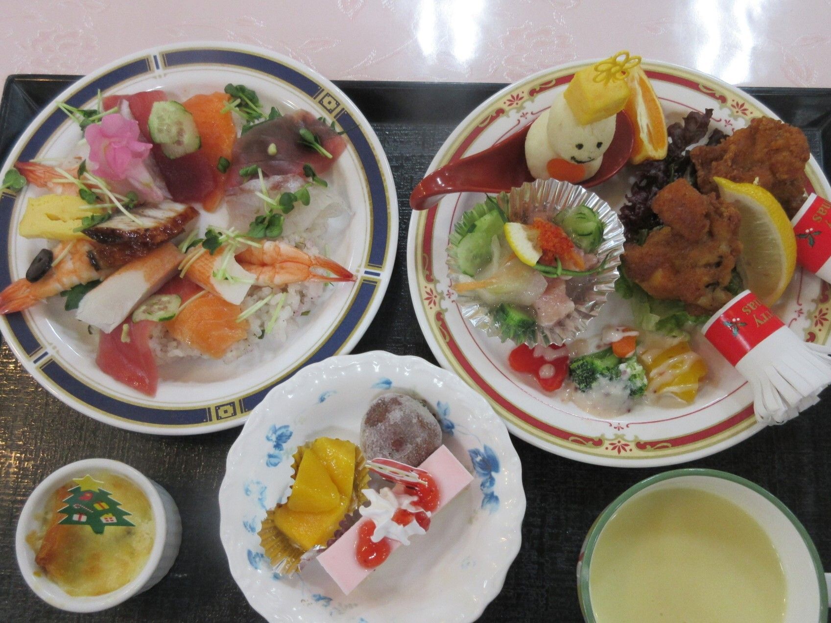 フライドチキンやエビが乗ったちらし寿司、サラダ、スープにミニグラタン、デザートが並んでいる。