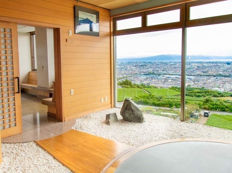 絵画が飾られた屋内にある枯山水庭園。共有部からフローリングの通路が続いていて、大きな窓の外には自然が広がっている。