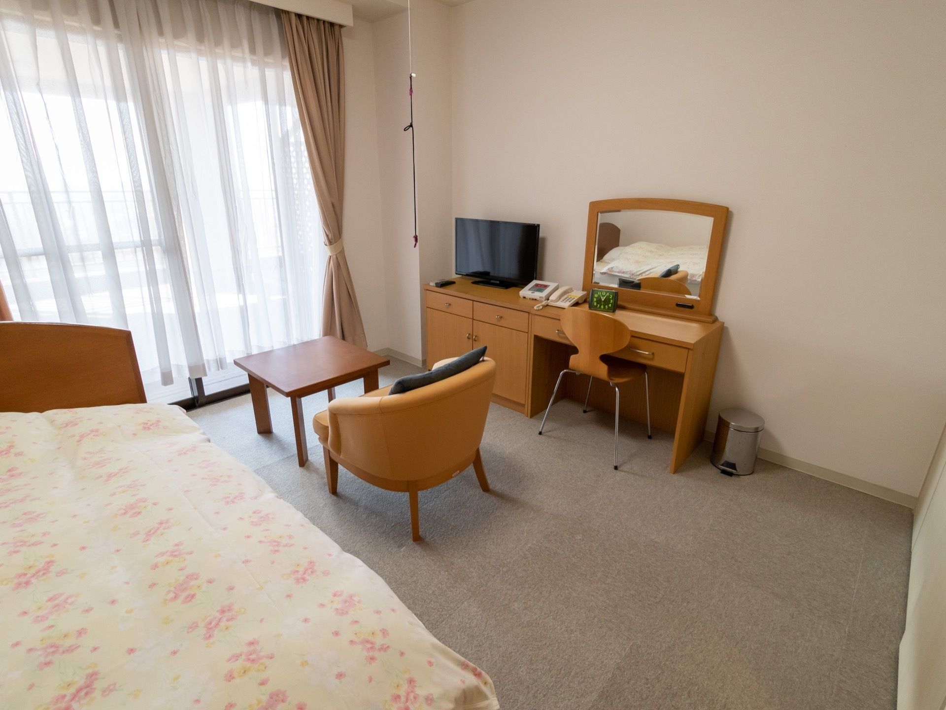 入居者様それぞれに割り当てられる居室の一例。床はカーペット敷きになっており、テレビ台とベッドの間に座席が置ける。