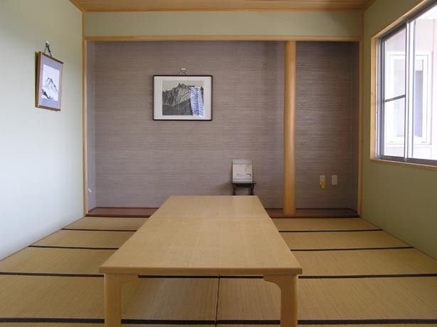 高齢者の方にタオルをかけてマッサージしているスタッフと振り返りながら会話する女性の様子