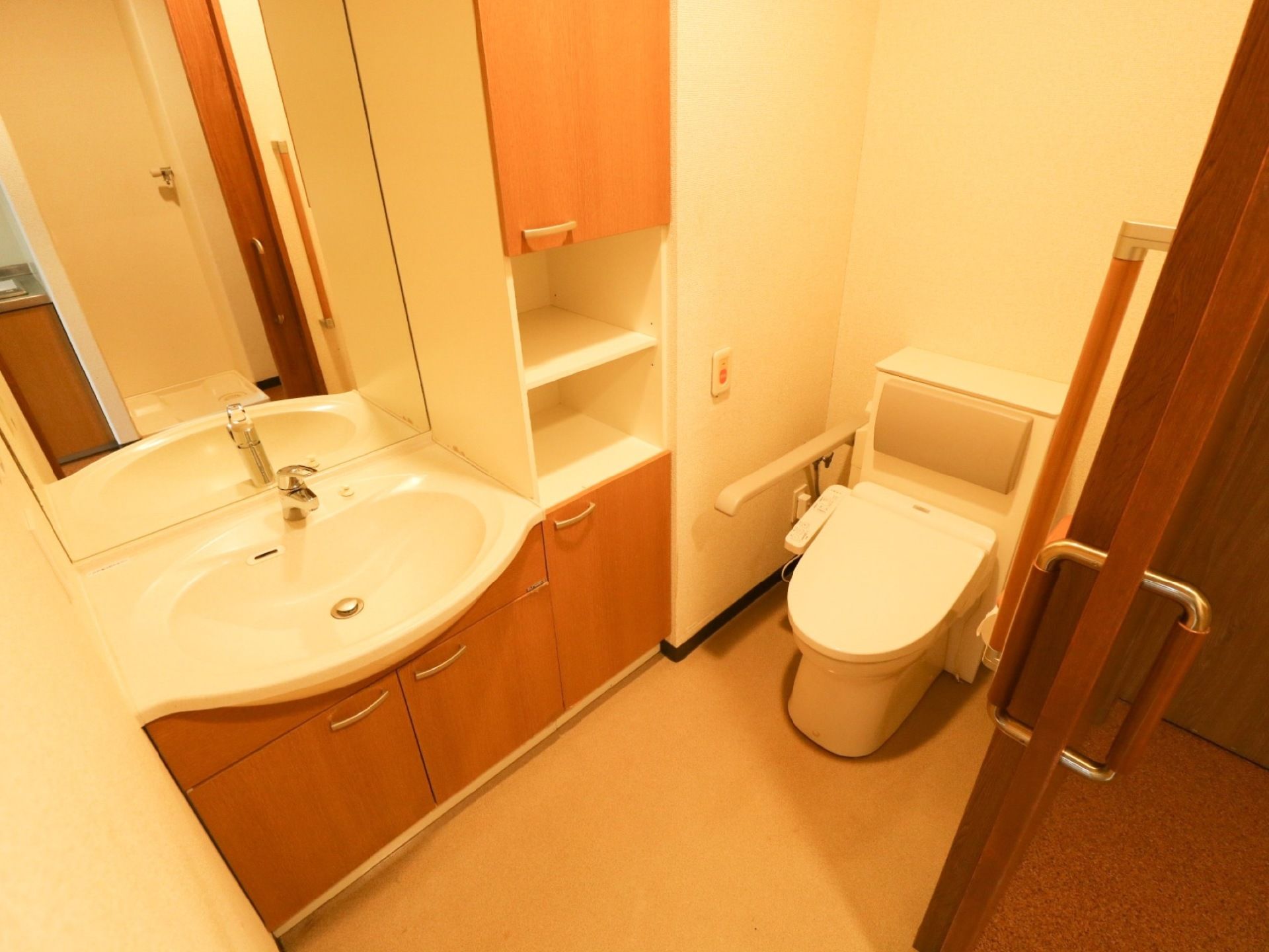 居室のトイレは、引き戸がついたスペースに設置されている。前面に大きな鏡がついた洗面台が同じスペース内にある。