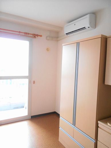 居室のエアコンの下に置かれている、下部に引き出しがついた収納家具