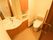 取っ手がついた引き戸を開けた所にトイレと洗面台がある。便座横の壁には呼び出しボタンがかかっている。