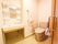 引き戸を開けた所にトイレとユニット洗面台が設置されている。壁には、縦横つながった手すりがついている。