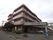 ワイン色で４階建ての建物の外観
