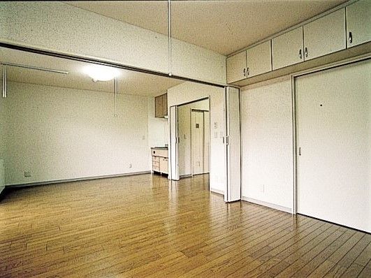 二人用の広い居室。天井まで収納スペースがあり、奥にはミニキッチンもある。