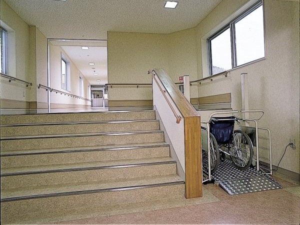 車いすが設置された商機が付いた階段。館内には手すりが設置されている。