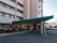 建物の玄関前には三角形の屋根が付いている。車を寄せられるスペースが設けられている。奥には駐車場がある。