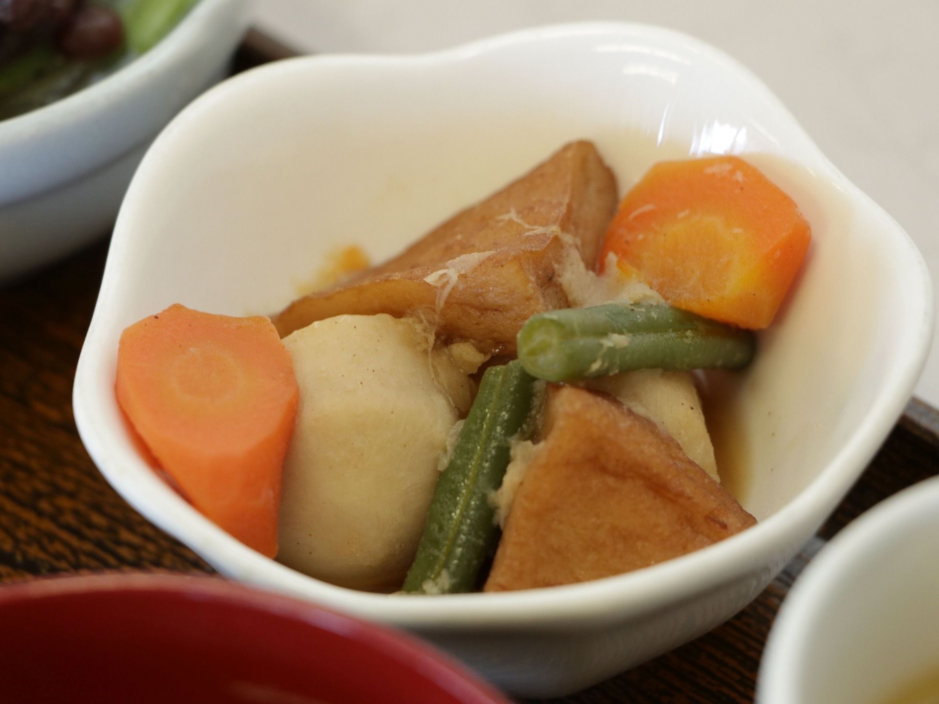 じっくりと煮込み、味が染み込んだ煮物が食事のトレーに乗っている。数種類の野菜と揚げが入っており、ボリュームもある。