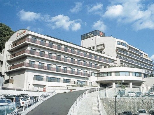 坂道の上にある大型施設の外観写真。ケアハウスグレイスフル下諏訪の外観
