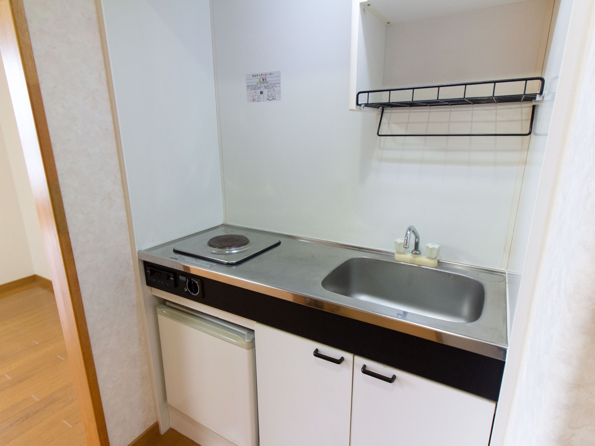 居室内にキッチンが取りつけられている。シンクに調理スペース、安全に使用できる電気調理器が設置されている。